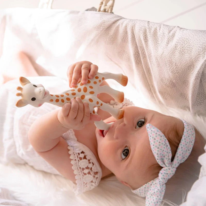 Un bébé jouant avec Sophie la girafe Bébé qui joue avec Sophie la Girafe